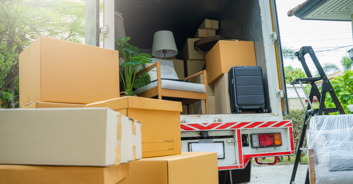 Moving truck loaded with boxes, furniture, and a suitcase in a residential area