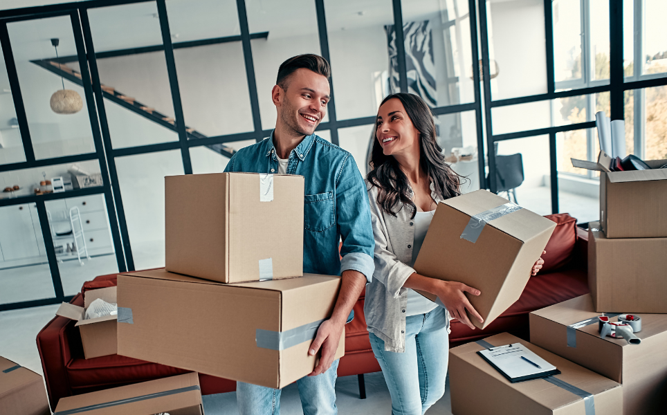 A happy couple holding cupboard moving boxes 